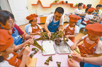 体验民俗：孩子们在幼儿园里与家长一起包粽子
