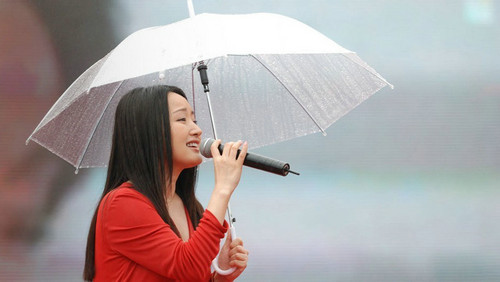 杨钰莹冒雨举伞献唱 疯狂男粉丝登台求合影