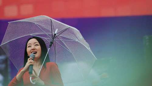 杨钰莹冒雨举伞献唱 疯狂男粉丝登台求合影